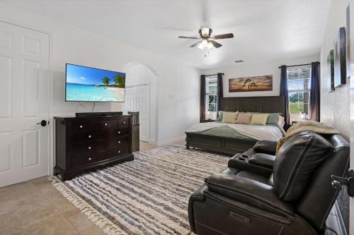 a bedroom with a bed and a couch and a television at Pampered Pillow in Canyon Lake