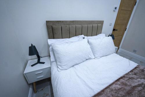 a bedroom with a bed with white sheets and pillows at Cozy Charming Bungalow BRAND NEW in Preston