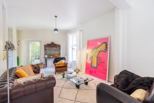 a living room with two couches and a painting on the wall at Domaine des Chanoines blancs in Gouy-Saint-André