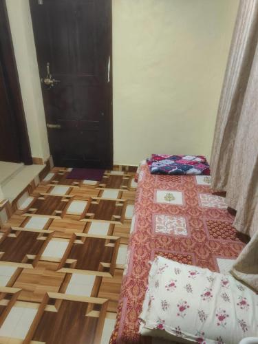 a room with a bed and a wooden floor at Gowri farm stay in Kōtatattu