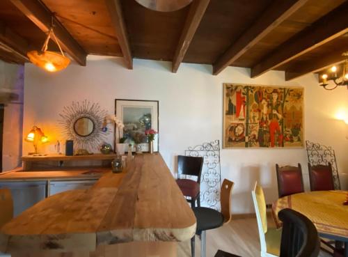 a dining room with a large wooden table and chairs at La Grange des zarts in Champagné-le-Sec