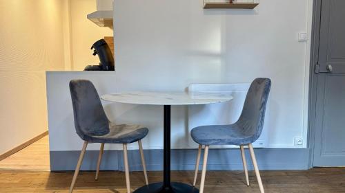 - deux chaises assises à côté d'une table dans la cuisine dans l'établissement Le clos lavon, à Nevers