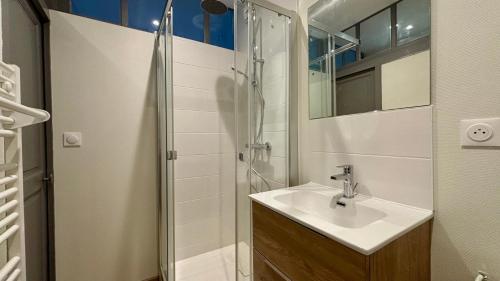 une salle de bain avec un lavabo et une douche dans l'établissement Le clos lavon, à Nevers