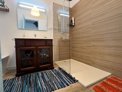 a bathroom with a shower with a wooden cabinet and a sink at Casas de Valtravieso El Jardín in El Pozo de los Frailes