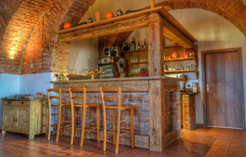 a bar in a kitchen with wooden stools at Penzion a restaurace Myslivna Kolence - Třeboňsko in Třeboň