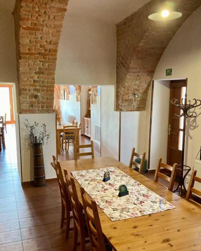 a dining room with a wooden table and chairs at Penzion a restaurace Myslivna Kolence - Třeboňsko in Třeboň