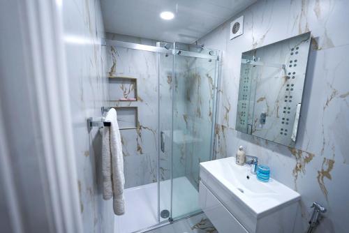 a bathroom with a glass shower and a sink at Cozy Charming Bungalow BRAND NEW in Preston