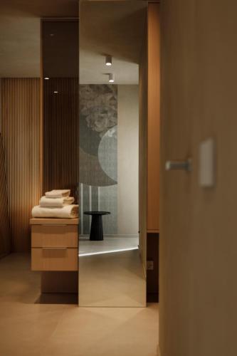 a bathroom with a sink and a table with towels at La Rotta Rooms in Agrigento