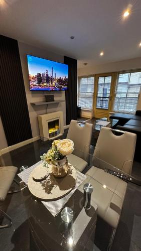 a living room with a table and a tv at 2 Bedroom Flat Ground Floor Town Centre Colchester in Colchester