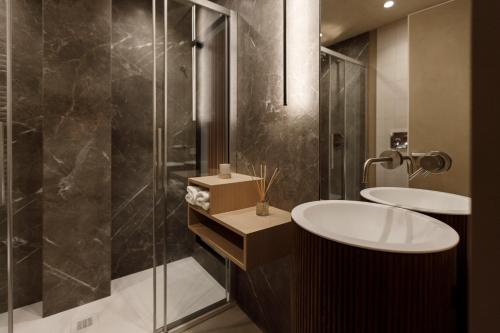 a bathroom with two sinks and a shower at La Rotta Rooms in Agrigento