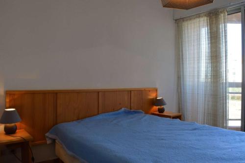 une chambre avec un lit bleu et une fenêtre dans l'établissement Appartement 2 pièces - 4 personnes - Saint Cyprien Plage SC150-220, à Saint Cyprien Plage