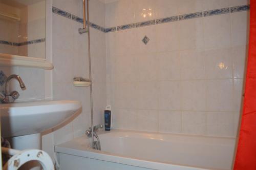 une salle de bain avec une baignoire blanche et un lavabo dans l'établissement SAINT CYPRIEN - Appartement 3 PIECES 6 Personnes SC060-106A, à Saint Cyprien Plage