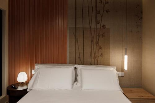 a bedroom with a bed with two white pillows at La Rotta Rooms in Agrigento