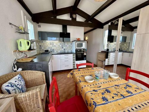 une cuisine avec une table et des chaises et une cuisine avec une table dans l'établissement Appartement studio cabine 4 couchages ST CYPRIEN PLAGE SC380-F274, à Saint Cyprien Plage
