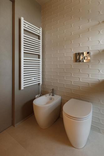 a bathroom with a white toilet and a sink at La Rotta Rooms in Agrigento
