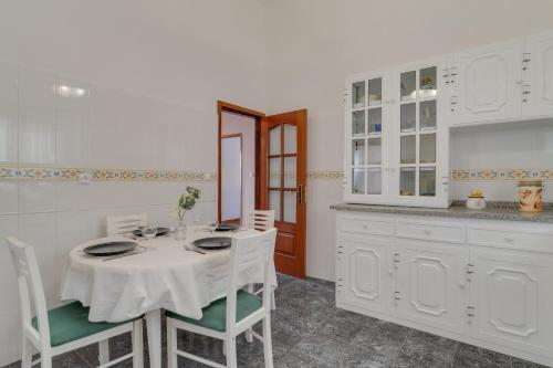a dining room with a table and chairs and a kitchen at Casa Moreira by AH in Caniçal