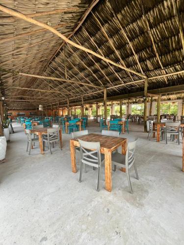 a pavilion with tables and chairs and a wooden ceiling at Hotel Arena Beach Cartagena in Cartagena de Indias