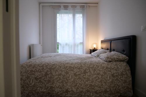 une chambre avec un grand lit avec une fenêtre dans l'établissement Bel appartement T2 cosy, à Colombes