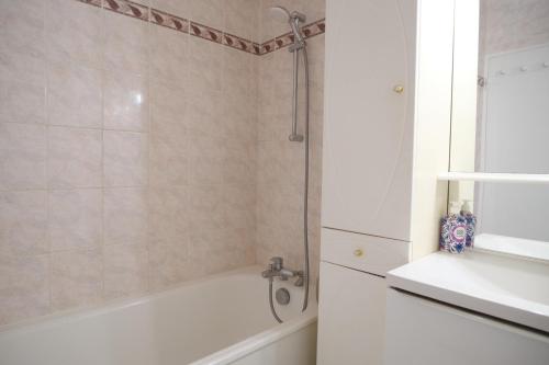 une salle de bain avec une baignoire blanche et un lavabo dans l'établissement Bel appartement T2 cosy, à Colombes