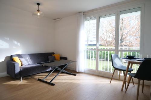 un salon avec un canapé et une table dans l'établissement Bel appartement T2 cosy, à Colombes