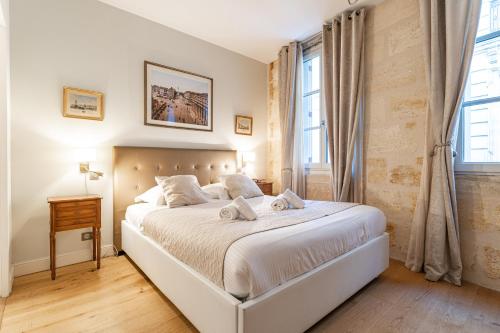 une chambre avec un lit blanc et une fenêtre dans l'établissement Appartements de charme au cœur de Bordeaux avec climatisation et rooftop, à Bordeaux