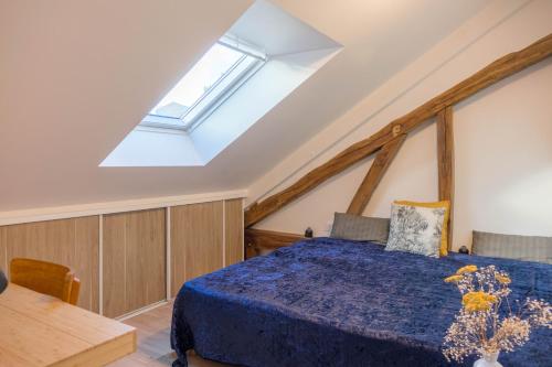 une chambre avec un lit et une lucarne dans l'établissement Domaine de charme au coeur d'Orléans classé 3 étoiles - Bords de Loire - 21 couchages avec parkings privés, à Orléans