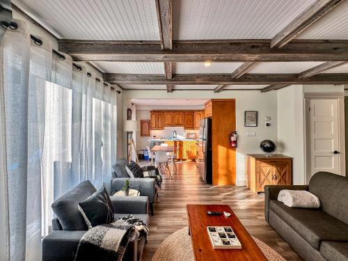 a living room with couches and a table and a kitchen at Hike BIke Chill in Collingwood