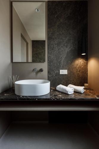 a bathroom with a white sink and a mirror at La Rotta Rooms in Agrigento