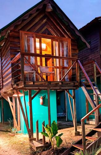 a wooden house with a balcony on the side of it at Pousada AldeiA Cotijuba in Belém