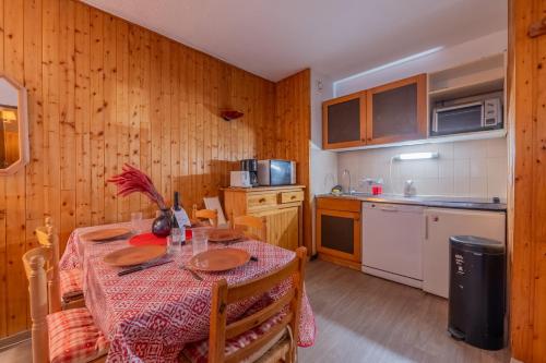 une cuisine avec une table recouverte d'une nappe dans l'établissement Chamonix Sud - Triolet A106 - Happy Rentals, à Chamonix-Mont-Blanc
