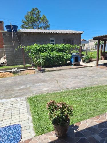 a yard with a potted plant and a house at Apartamento Aconchegante in Tramandaí