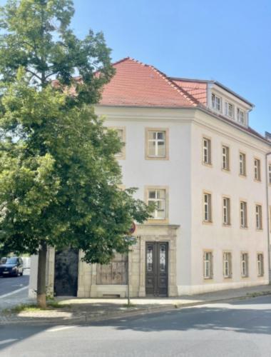 a large white building with a red roof at Apartmenthaus Burkhardt - Doppelzimmer und Apartments in Meißen