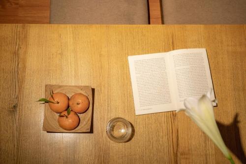 a book and some fruit on a wooden table at Old Quarter 6 Senses 3Br Hoan Kiem in Hanoi