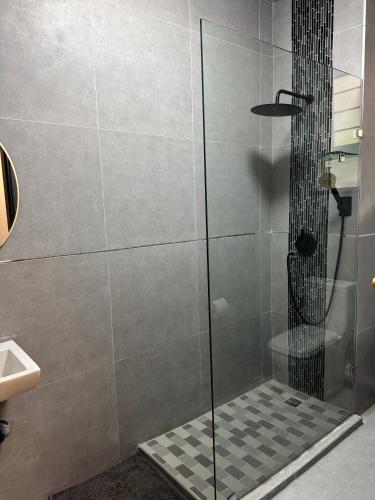 a shower with a glass door in a bathroom at Ridge Royal in Amanzimtoti
