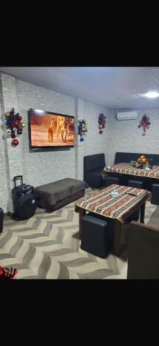a living room with two tables and a flat screen tv at Guesthouse with event venue in Argavand