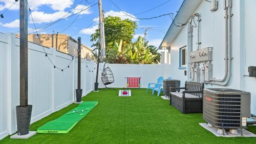 a patio with green grass on a house at The Shark Tank Cocoa Beach - Retro Florida, Downtown, 5-Min Walk to Beach, Shops & Bars in Cocoa Beach