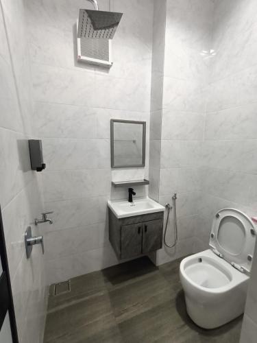 a bathroom with a toilet and a sink and a mirror at RINA HOMESTAY Kemaman in Cukai