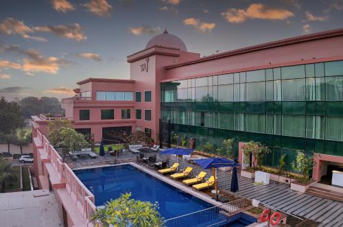 a hotel with a pool in front of a building at Taj Agra in Agra
