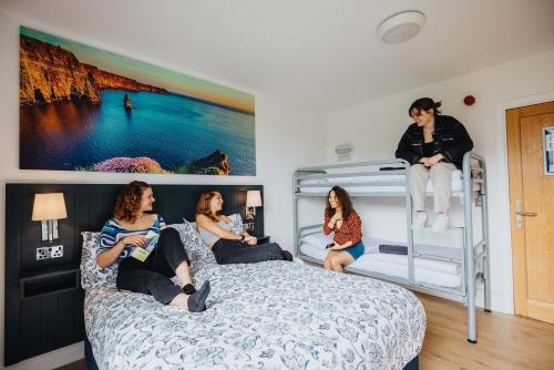 a group of girls sitting on a bed in a bedroom at Snoozles Galway City Centre in Galway