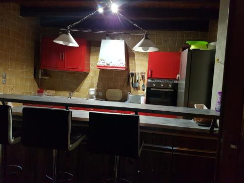 - une cuisine avec des placards rouges et un réfrigérateur noir dans l'établissement Appartement 4 personnes meublé, à Marlenheim