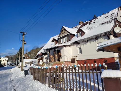 a house with a fence in the snow at U Efy in Josefuv dul