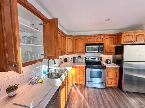 a kitchen with wooden cabinets and stainless steel appliances at Hike BIke Chill in Collingwood