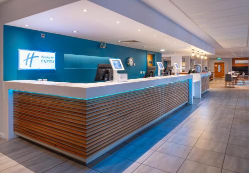 a lobby of a hotel with a blue wall at Holiday Inn Express Stevenage by IHG in Stevenage