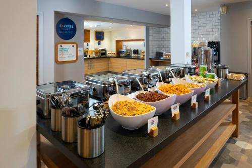 a buffet line with bowls of food on a counter at Holiday Inn Express Stevenage by IHG in Stevenage