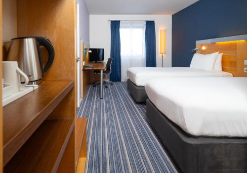 a hotel room with a large bed and a desk at Holiday Inn Express Stevenage by IHG in Stevenage