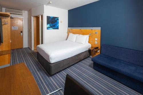 a hotel room with a bed and a couch at Holiday Inn Express Stevenage by IHG in Stevenage