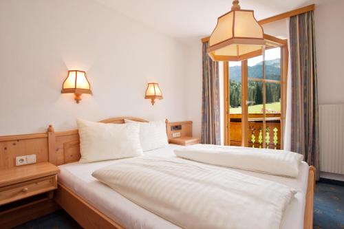 a bedroom with two beds and a window at Berghotel Lämmerhof in Sankt Martin am Tennengebirge