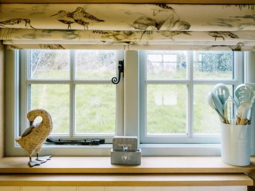 a bird sitting on a window sill in a kitchen at Herbie's Shepherds Hut at Shepherds Lodge Retreat and Wellness in Nottingham
