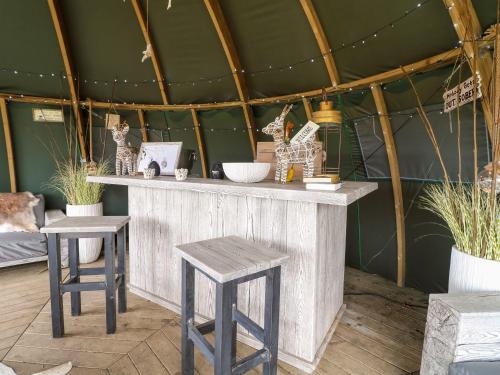 a wooden counter with two stools in a room at Herbie's Shepherds Hut at Shepherds Lodge Retreat and Wellness in Nottingham