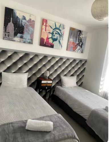 - une chambre avec 2 lits et des photos sur le mur dans l'établissement Maison aux portes de sologne, à Vierzon